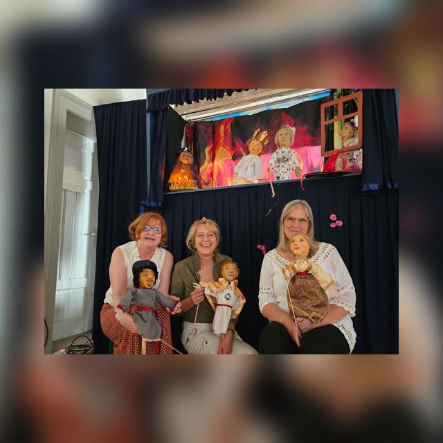 Drei Puppenspielerinnen des Teatro La PeCoMo präsentieren ihre Puppen vor der Bühne